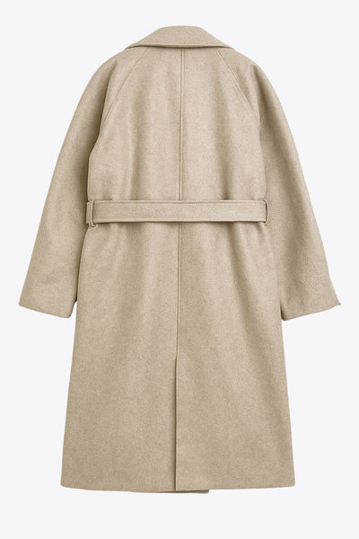 Abrigo largo de corte en a, con solapa, manga larga con puño abotonado en contraste y bolsillos frontales con cartera. Detalle de trabillas, cinturón amarrable del mismo tejido y abertura posterior.