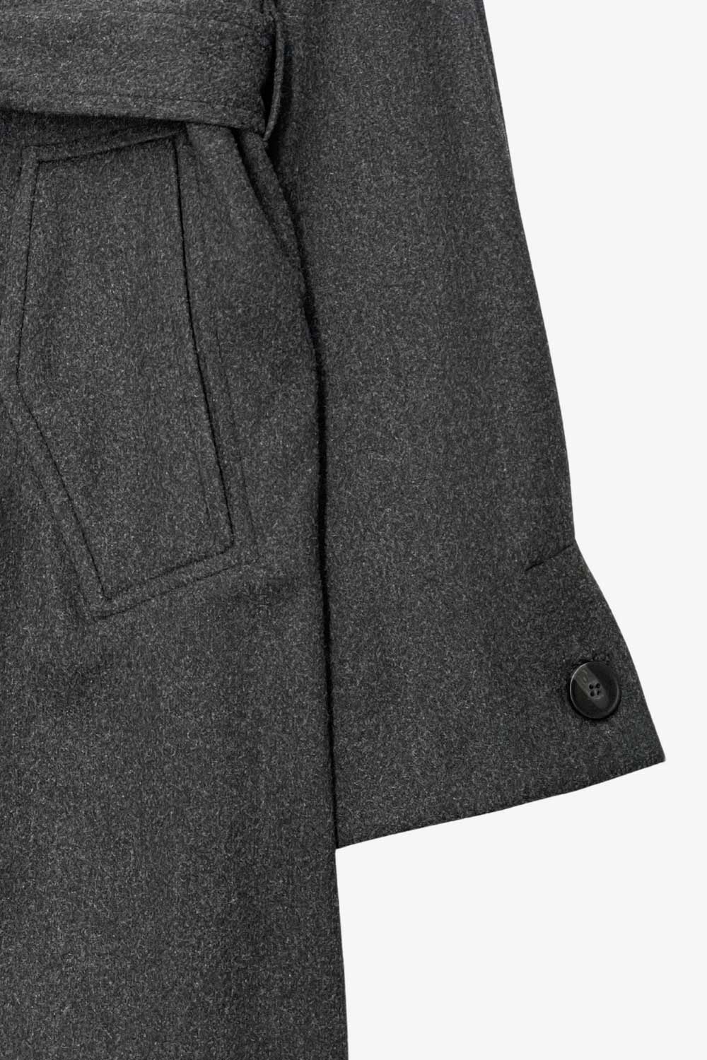 Abrigo largo de corte en a, con solapa, manga larga con puño abotonado en contraste y bolsillos frontales con cartera. Detalle de trabillas, cinturón amarrable del mismo tejido y abertura posterior.