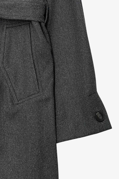 Abrigo largo de corte en a, con solapa, manga larga con puño abotonado en contraste y bolsillos frontales con cartera. Detalle de trabillas, cinturón amarrable del mismo tejido y abertura posterior.