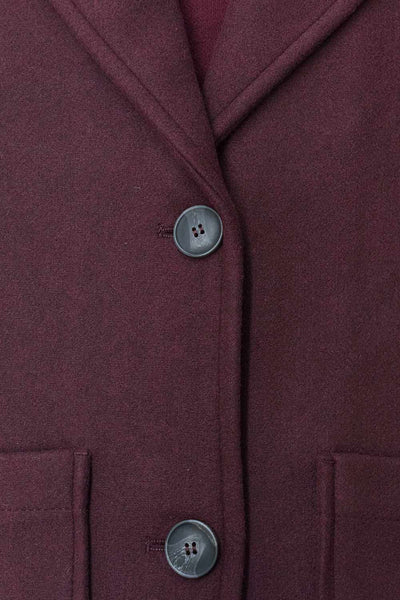 Abrigo largo de fit recto, manga larga, con solapa, bolsillos delanteros de parche y cierre frontal con cruce de botones en contraste.