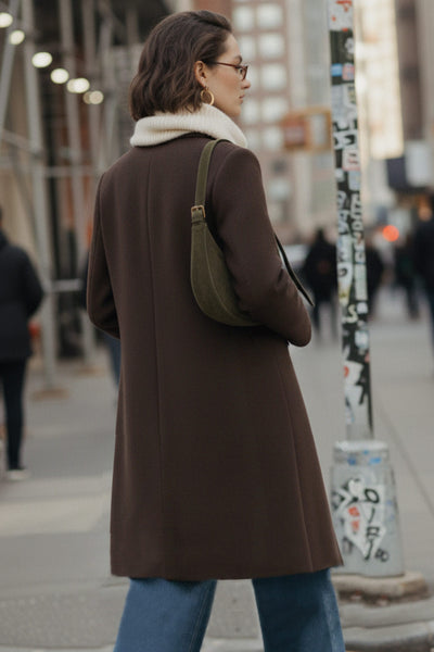 Abrigo largo de fit recto, con solapa, manga larga y cierre frontal con cruce de botón en contraste.