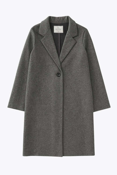 Abrigo largo de fit recto, con solapa, manga larga y cierre frontal con cruce de botón en contraste.
