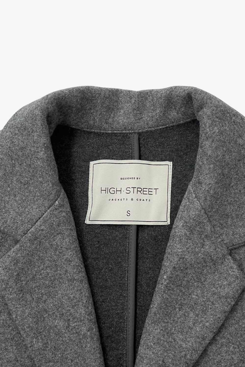 Abrigo largo de fit recto, con solapa, manga larga y cierre frontal con cruce de botón en contraste.