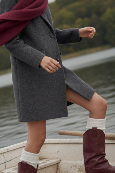 Abrigo largo de fit recto, con solapa y hombreras, manga larga, bolsillos delanteros con vivos y cierre frontal con botones en contraste.