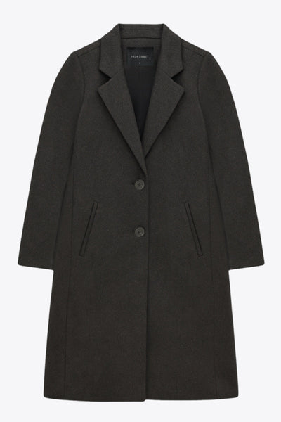 Abrigo largo de fit recto, con solapa y hombreras, manga larga, bolsillos delanteros con vivos y cierre frontal con botones en contraste.