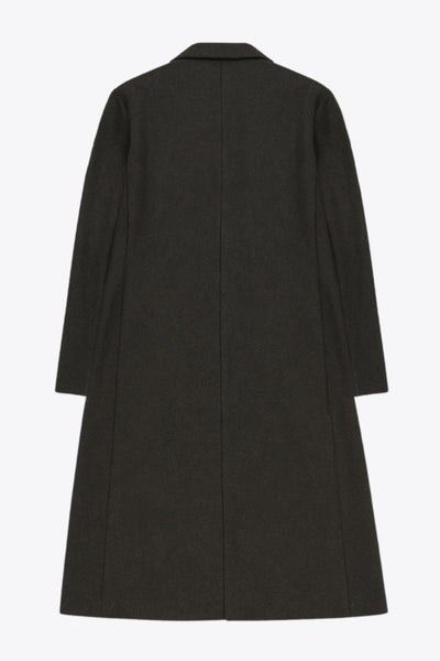 Abrigo largo de fit recto, con solapa y hombreras, manga larga, bolsillos delanteros con vivos y cierre frontal con botones en contraste.