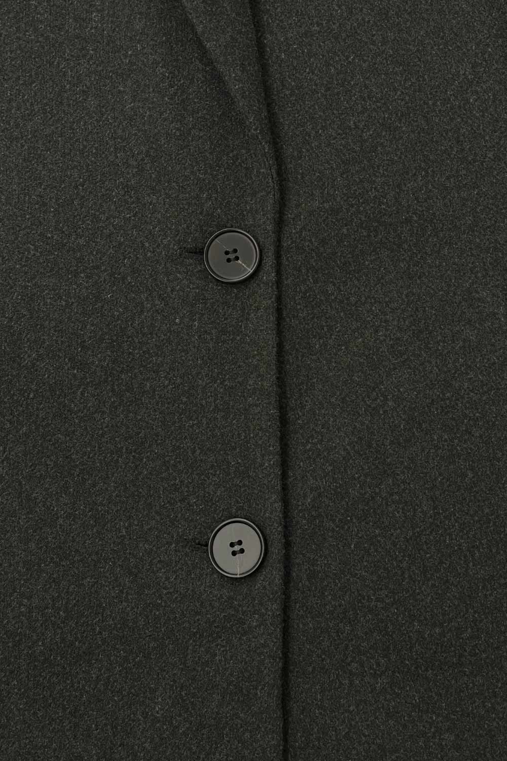 Abrigo largo de fit recto, con solapa y hombreras, manga larga, bolsillos delanteros con vivos y cierre frontal con botones en contraste.