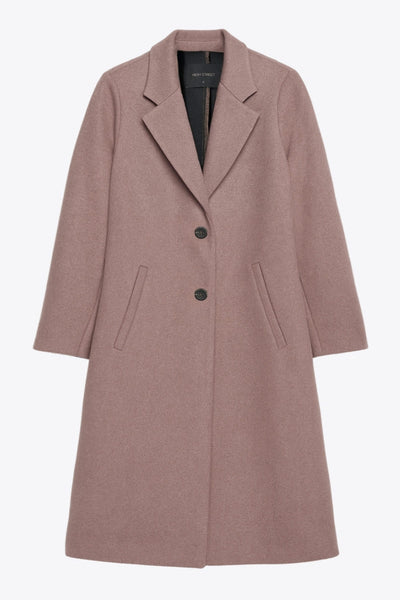 Abrigo largo de fit recto, manga larga, con solapa, bolsillos con vivos delanteros. Cierre frontal con cruce de botones en contraste.