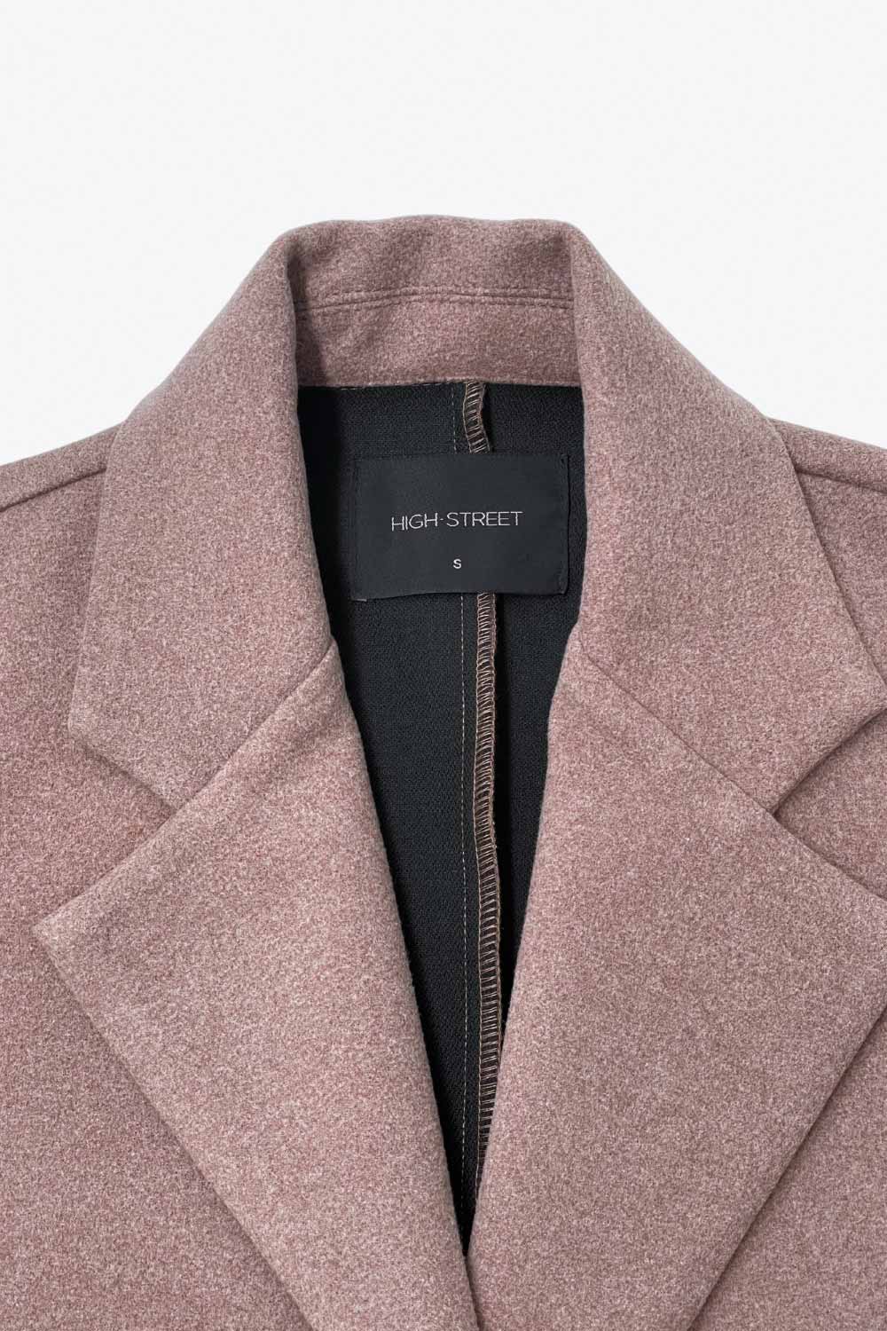 Abrigo largo de fit recto, manga larga, con solapa, bolsillos con vivos delanteros. Cierre frontal con cruce de botones en contraste.