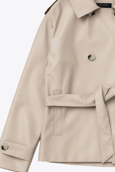 Abrigo trench corto de fit recto, cuello solapa, manga larga, trabillas con botón en puños y hombros. Bolsillos delanteros con vivos, trabillas y cinturón amarrable del mismo tejido. Cierre frontal con doble cruce de botones en contraste.