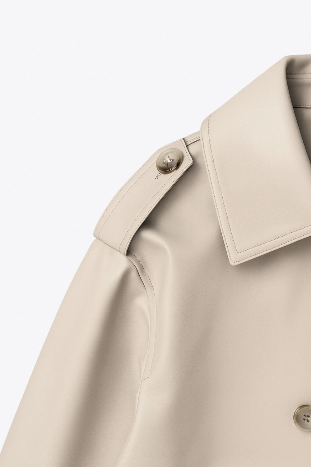 Abrigo trench corto de fit recto, cuello solapa, manga larga, trabillas con botón en puños y hombros. Bolsillos delanteros con vivos, trabillas y cinturón amarrable del mismo tejido. Cierre frontal con doble cruce de botones en contraste.