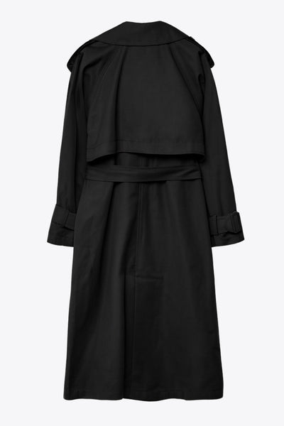 Abrigo trench corto de fit recto, con solapa, bolsillos delanteros con vivos, detalle de bata trasera y manga larga. Trabillas, cinturón amarrable del mismo tejido y cierre frontal con doble cruce de botones en contraste. Detalle de trabilla y botón en hombros, bata trasera y puños.