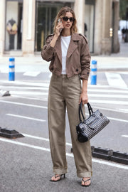 Abrigo trench corto de fit abullonado, cuello solapa, manga larga con trabillas con botón en puños y hombros. Detalle de bata decorativa frontal y cierre con doble cruce de botón en contraste. Detalle de plisados en bajo.