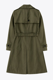 Abrigo trench corto de fit recto, con cuello solapa, bolsillos delanteros con vivos, detalle de bata trasera y manga larga. Trabillas, cinturón amarrable del mismo tejido y cierre frontal con doble cruce de botones en contraste. Detalle de trabilla y botón en hombros, bata trasera, cuello y puños.