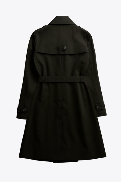 Abrigo trench corto de fit recto, con cuello solapa, bolsillos delanteros con vivos, detalle de bata trasera y manga larga. Trabillas, cinturón amarrable del mismo tejido y cierre frontal con doble cruce de botones en contraste. Detalle de trabilla y botón en hombros, bata trasera, cuello y puños.