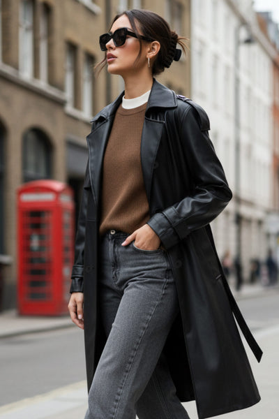 Abrigo trench de efecto piel, fit recto, con solapa, bolsillos delanteros con vivos, abertura posterior en bajo, bata trasera y manga larga. Cinturón amarrable del mismo tejido y cierre frontal con doble cruce de botones. Detalle de trabilla y botón en hombros y puños.