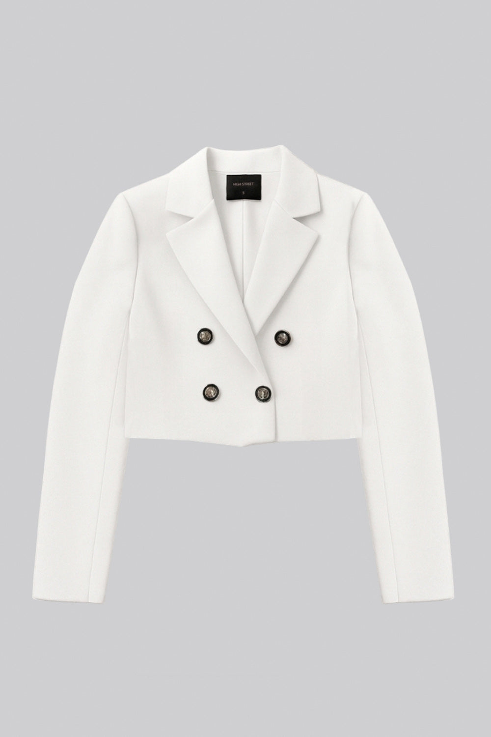 Blazer corto abierto, de fit recto, con solapa y hombreras, manga larga y detalle frontal de botones decorativos en contraste.
