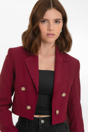 Blazer corto abierto de fit recto, con hombreras y solapa, manga larga y botones decorativos frontales en contraste.