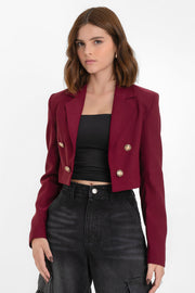 Blazer corto abierto de fit recto, con hombreras y solapa, manga larga y botones decorativos frontales en contraste.