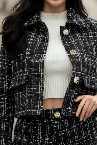 Blazer corto de bouclé, fit recto, con cuello solapa, manga larga, bolsillos delanteros con cartera y cierre frontal con hilera de botones en contraste.