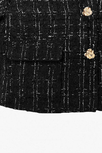 Blazer corto de bouclé, fit recto, con cuello solapa, manga larga, bolsillos delanteros con cartera y cierre frontal con hilera de botones en contraste.