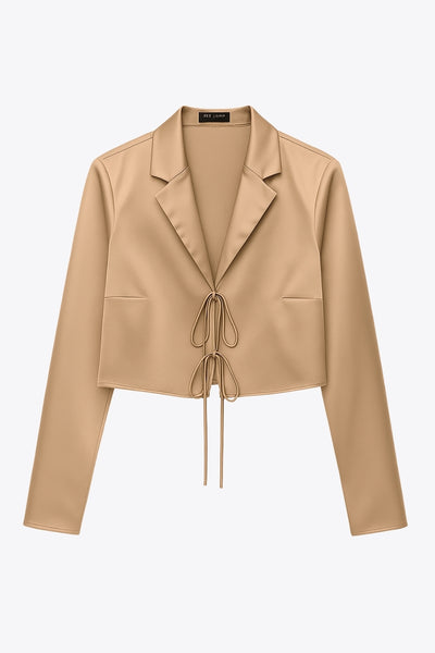 Blazer corto satinado de fit recto, manga larga, con solapa y cierre frontal con doble lazo amarrable.