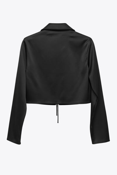Blazer corto satinado de fit recto, manga larga, con solapa y cierre frontal con doble lazo amarrable.