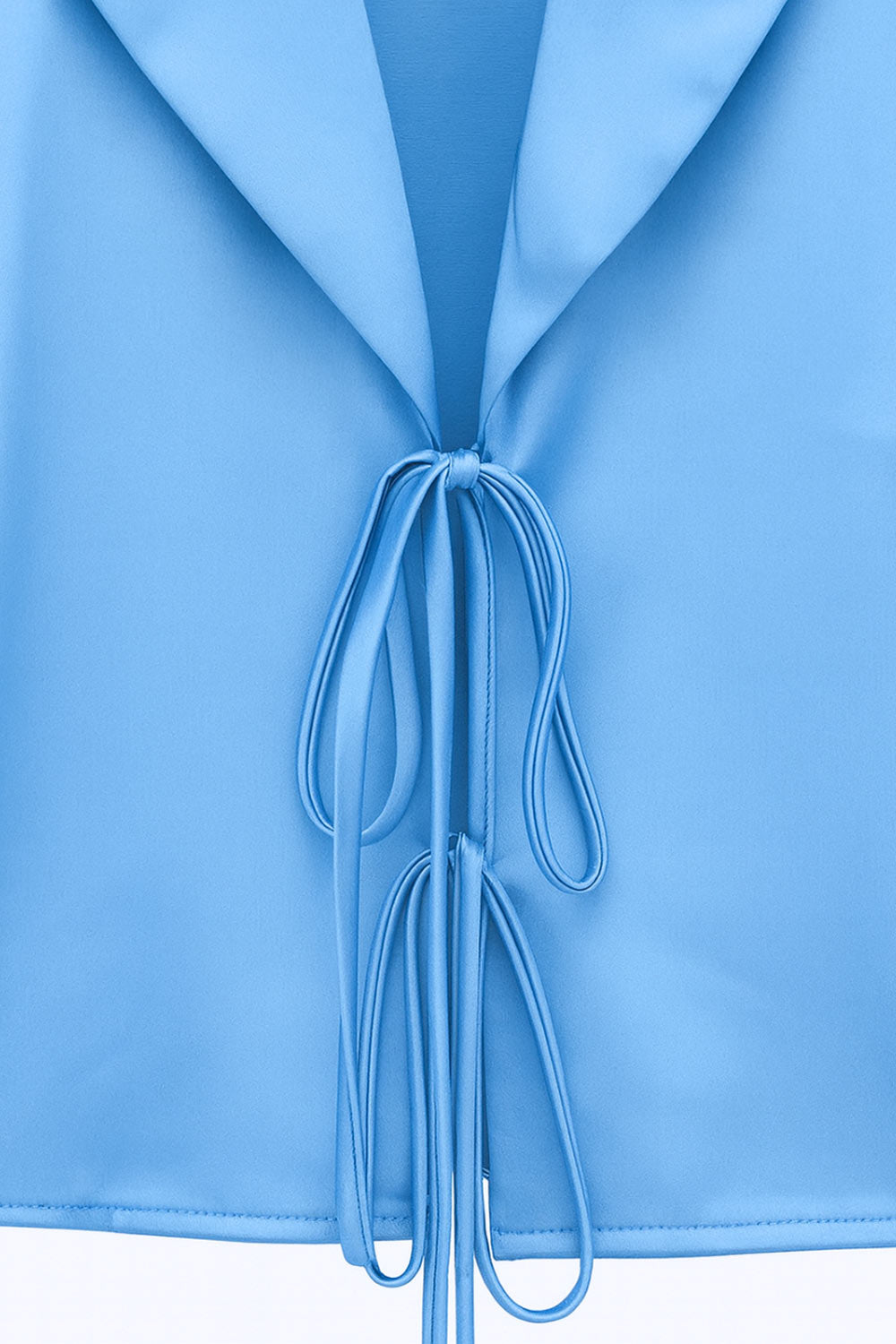 Blazer corto satinado de fit recto, manga larga, con solapa y cierre frontal con doble lazo amarrable.