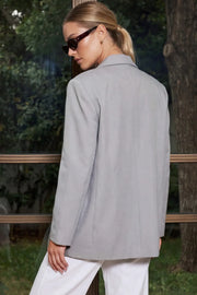 Blazer cruzado de fit oversized, con solapa y hombreras, manga larga, vivo frontal, bolsillos delanteros con cartera. Cierre frontal con cruce de botones.