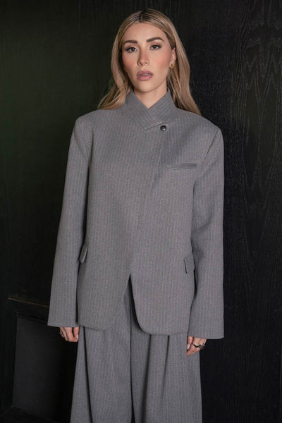 Blazer cruzado de fit oversized, estampado rayas, con cuello solapa cruzado y hombreras, manga larga, vivo frontal, bolsillos delanteros con cartera. Cierre frontal con botón.