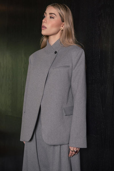 Blazer cruzado de fit oversized, estampado rayas, con cuello solapa cruzado y hombreras, manga larga, vivo frontal, bolsillos delanteros con cartera. Cierre frontal con botón.