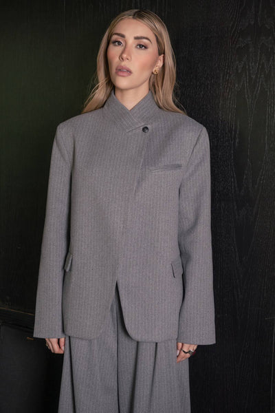 Blazer cruzado de fit oversized, estampado rayas, con cuello solapa cruzado y hombreras, manga larga, vivo frontal, bolsillos delanteros con cartera. Cierre frontal con botón.