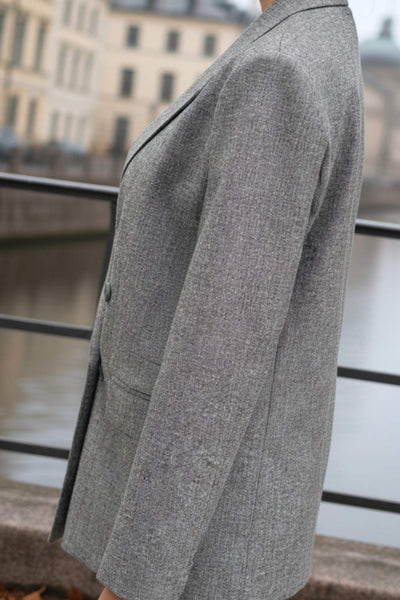 Blazer cruzado de fit oversized, con solapa y hombreras, manga larga, bolsillos delanteros con cartera y cierre frontal con cruce de botones.