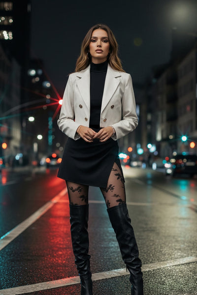 Blazer corto abierto de efecto piel, fit recto, con hombreras y solapa, manga larga y botones decorativos frontales en contraste.