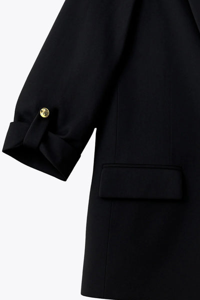 Blazer abierto de fit ligeramente oversized, manga 3/4 rolled up con trabilla decorativa y botón en contraste. Detalle de bolsillos delanteros con cartera.