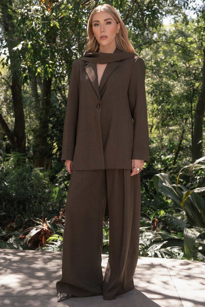 Blazer de fit oversized, con solapa y hombreras, manga larga, bolsillos delanteros con vivos y cierre frontal con botón. Detalle decorativo en cuello.