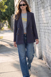 Blazer cruzado de fit oversized, estampado rayas, con solapa y hombreras, manga larga, bolsillos delanteros con cartera. Cierre frontal con doble botón en contraste.