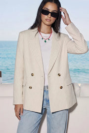 Blazer cruzado de fit oversized, estampado rayas, con solapa y hombreras, manga larga, bolsillos delanteros con cartera. Cierre frontal con doble botón en contraste.