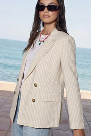 Blazer cruzado de fit oversized, estampado rayas, con solapa y hombreras, manga larga, bolsillos delanteros con cartera. Cierre frontal con doble botón en contraste.