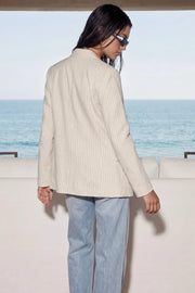 Blazer cruzado de fit oversized, estampado rayas, con solapa y hombreras, manga larga, bolsillos delanteros con cartera. Cierre frontal con doble botón en contraste.