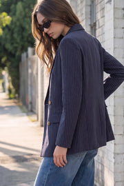 Blazer cruzado de fit oversized, estampado rayas, con solapa y hombreras, manga larga, bolsillos delanteros con cartera. Cierre frontal con doble botón en contraste.