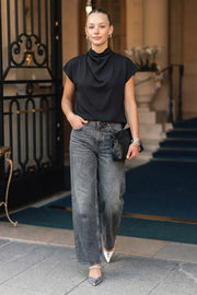 Blusa fluida de manga corta seguida, cuello mock seguido con plisados decorativos en hombro y cuello. Cierre posterior con botones y ojales.