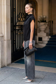 Blusa fluida de manga corta seguida, cuello mock seguido con plisados decorativos en hombro y cuello. Cierre posterior con botones y ojales.