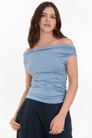 Blusa de fit ajustado, manga corta seguida con plisados en laterales, hombros descubiertos, plisados en costados y escote recto.