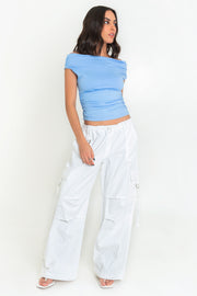 Blusa de fit ajustado, manga corta seguida con plisados en laterales, hombros descubiertos, plisados en costados y escote recto.