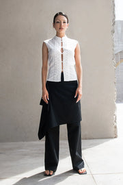 Blusa de fit ajustado, sin mangas, cuello mao, cut out frontal con hilera de botones y detalle de textura en tejido. Detalle de encaje decorativo.
