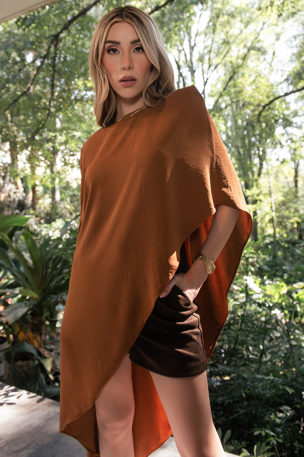 Blusa tipo túnica asimétrica, de cuello redondo, con hombreras, manga corta seguida, fit fluido y bajo asimétrico.