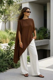 Blusa tipo túnica asimétrica, de cuello redondo, con hombreras, manga corta seguida, fit fluido y bajo asimétrico.