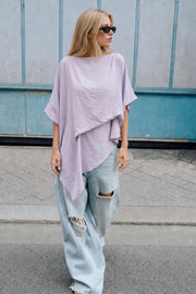 Blusa asimétrica de fit fluido, manga seguida con olanes, plisados y capas de olanes decorativos. Detalle de bajo asimétrico y textura en tejido.