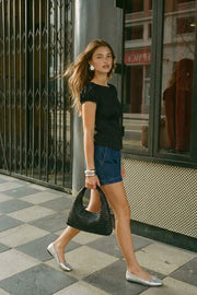 Blusa corta de rayas, fit ajustado, manga corta abullonada con rib elástico en borde, cuello redondo y cierre frontal con botones. Detalle de cortes y plisados decorativos frontales.